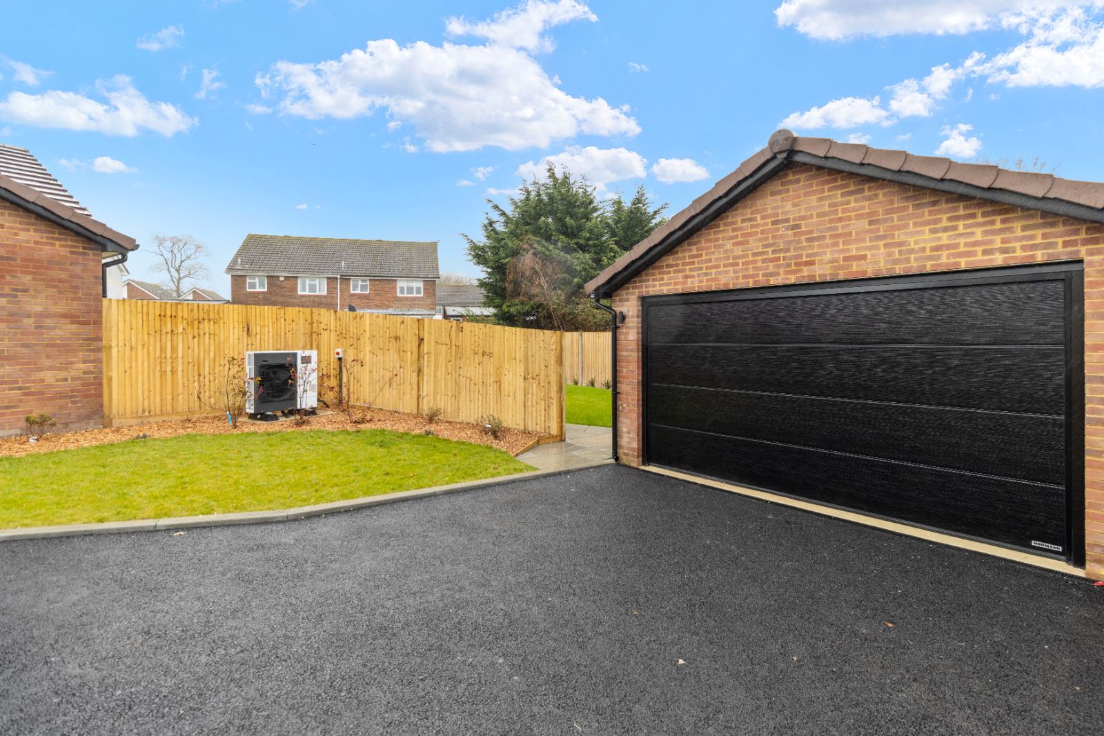 1A The Drive: detached double garage, tarmac drive and air source heat pump, by Bramall Homes