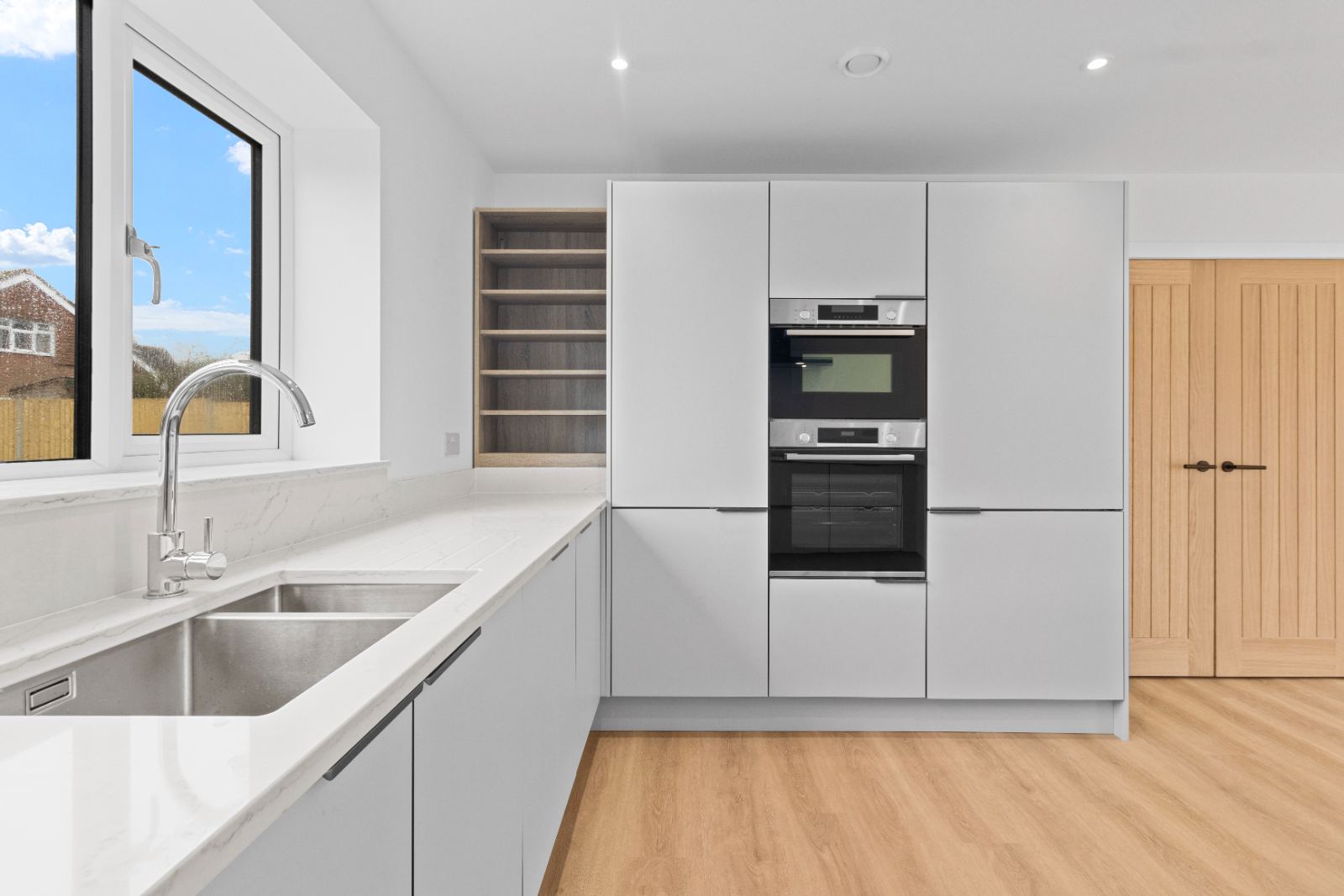 1A The Drive: tall units with double oven and open shelving, by Bramall Homes