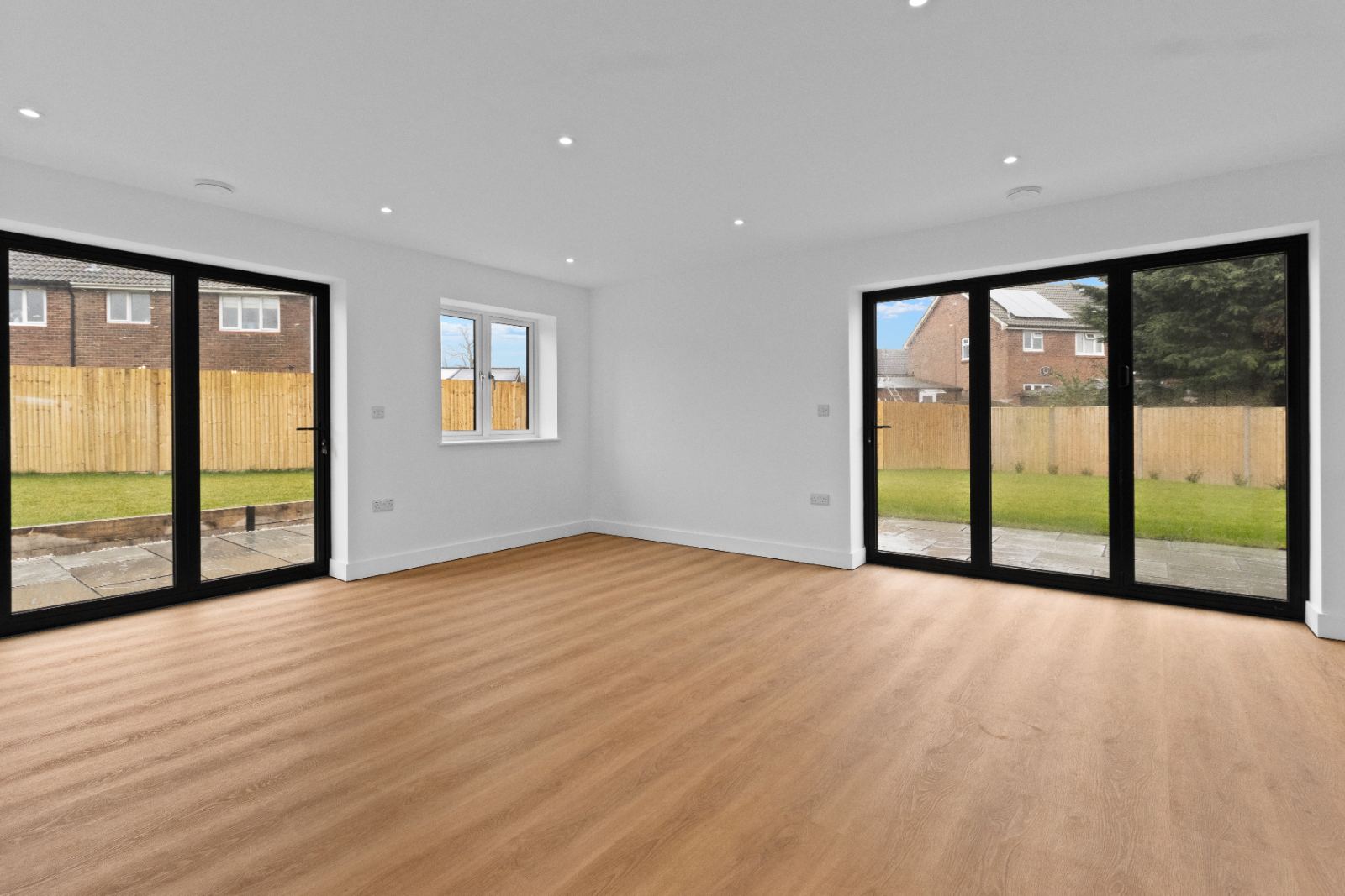1A The Drive: living room with two sets of bifold doors, built by Bramall Homes