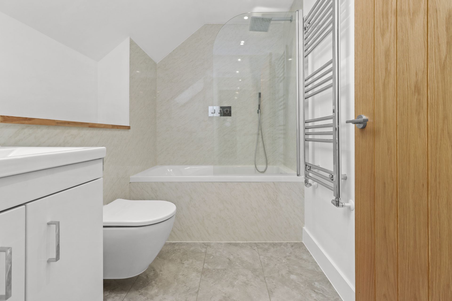 Bramley Barn, Burwash: bathroom with bath and shower over, in the roof space, by Bramall Homes