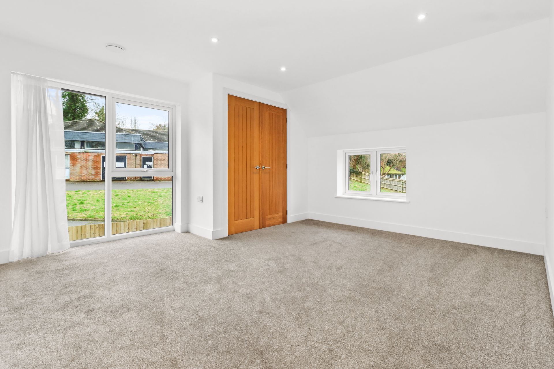 Bramley Barn, Burwash: bedroom with oak doors and countryside outlook, by Bramall Homes