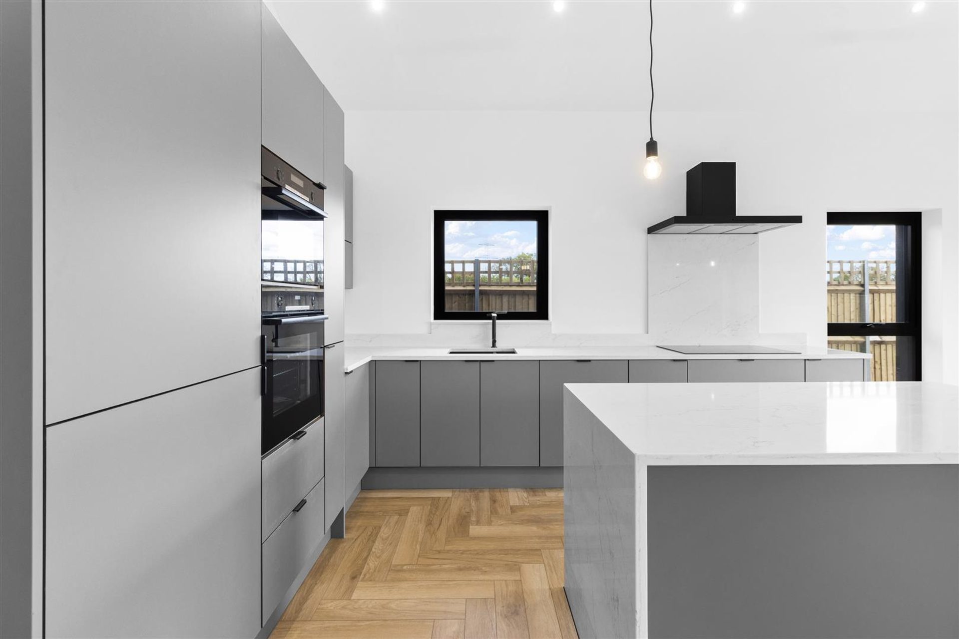 Bridlewood Barn, Horam: kitchen with island under the vaulted ceiling, by Bramall Homes