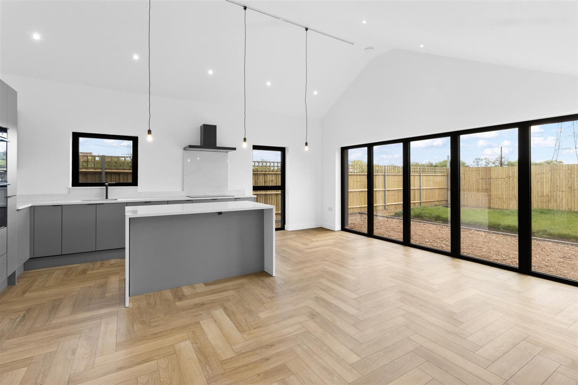 Bridlewood Barn, Horam: vaulted open plan kitchen and living space with glazing to the garden, by Bramall Homes